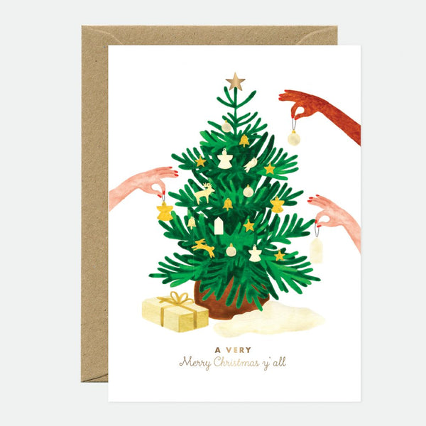 Illustrated Christmas greeting card depicting a green Christmas tree with gold foil details, accompanied by a brown envelope.