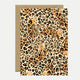 A birthday greeting card with a leopard animal print and gold foil details, accompanied by a recycled brown envelope.