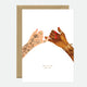 A greeting card with a gold foil design featuring two hands forming a heart shape, with the phrase 'Bitches forever - Girl power' at the bottom.