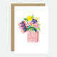 Greeting card with an illustration of a lighter surrounded by various flowers, presented with a brown envelope.