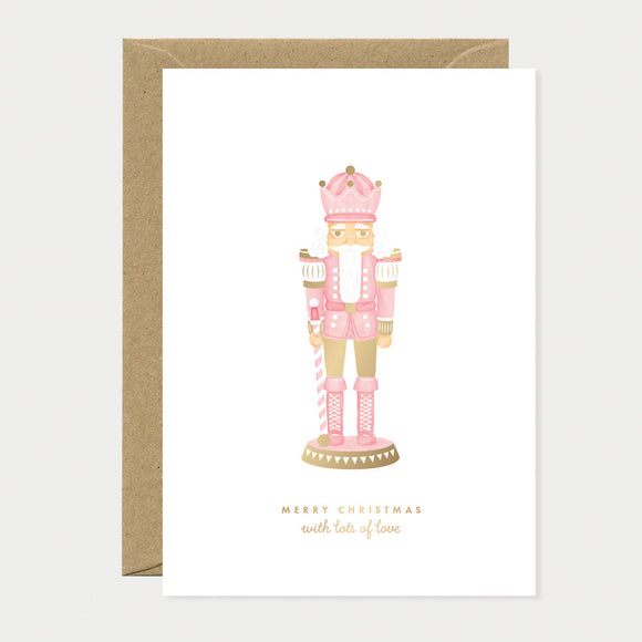 Greeting card with a pink nutcracker soldier and gold foil accents, combining modern elegance with traditional Christmas charm.