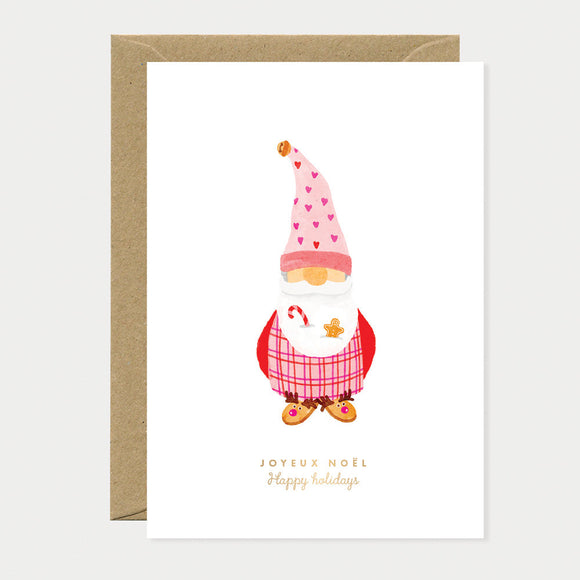 Greeting card with a festive Christmas gnome in pink and red, wearing a heart hat and holding candy cane and gingerbread cookie, symbolizing holiday cheer.