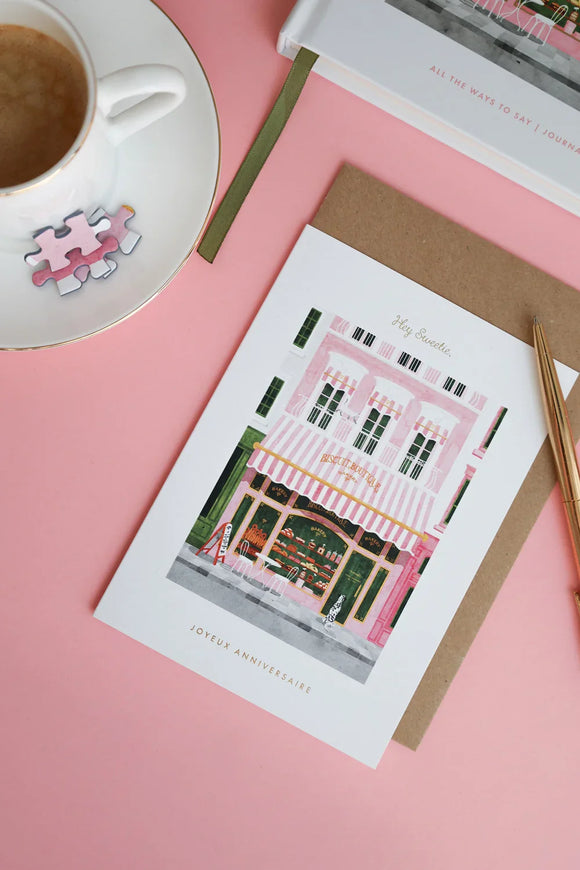 Birthday card “Hey Sweetie” with pink bakery storefront illustration, envelope and coffee cup — All the Ways to Say stationery on pink background.