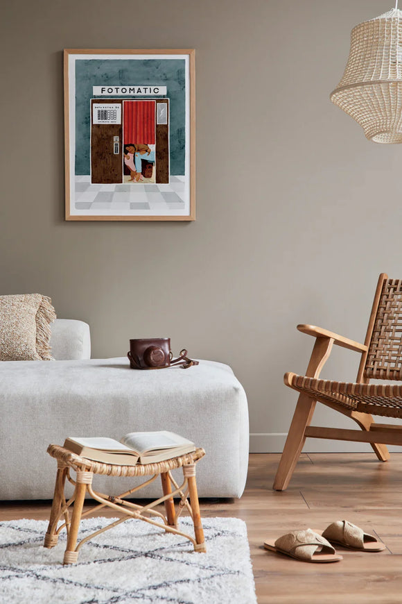 Fotomatic art print framed on a beige wall in a minimalist living room with wooden and rattan furniture