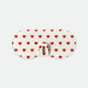 White glasses case with red hearts pattern and gold logo plate on clasp displayed on a light background