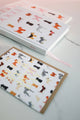 Dogue notebook with illustrated dogs styled on desk alongside matching greeting card for stationery lovers.