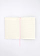 Open Dogue notebook showing lined cream pages with pink ribbon bookmark for writing and journaling.