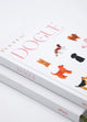 Detailed angled view of Dogue notebook cover with playful illustrated dogs and pink typography.