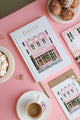 Bakery Daily Journal by All the Ways to Say standing on a white marble pedestal, with a choux pastry and pink background for a soft lifestyle setting.