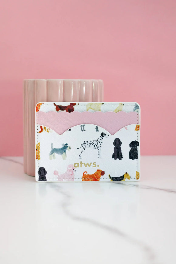 Dog pattern card holder with pink scalloped leather detail and atws gold logo, styled upright against pink background.