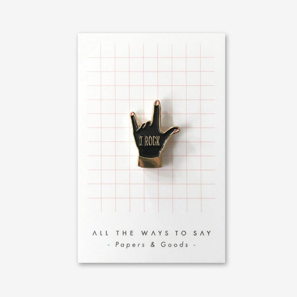 I Rock enamel pin by All the Ways to Say featuring black hand design with gold-plated finish and “I Rock” text, perfect for rock-inspired accessories.