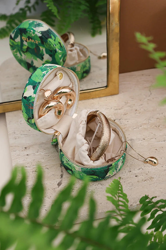 Green tropical jewelry box with leafy pattern, shown open with gold jewelry inside