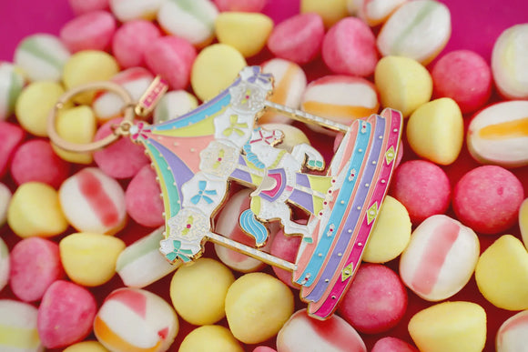 Close-up of Merry Go Round enamel keychain by All The Ways To Say – horse and carousel details in gold and pink