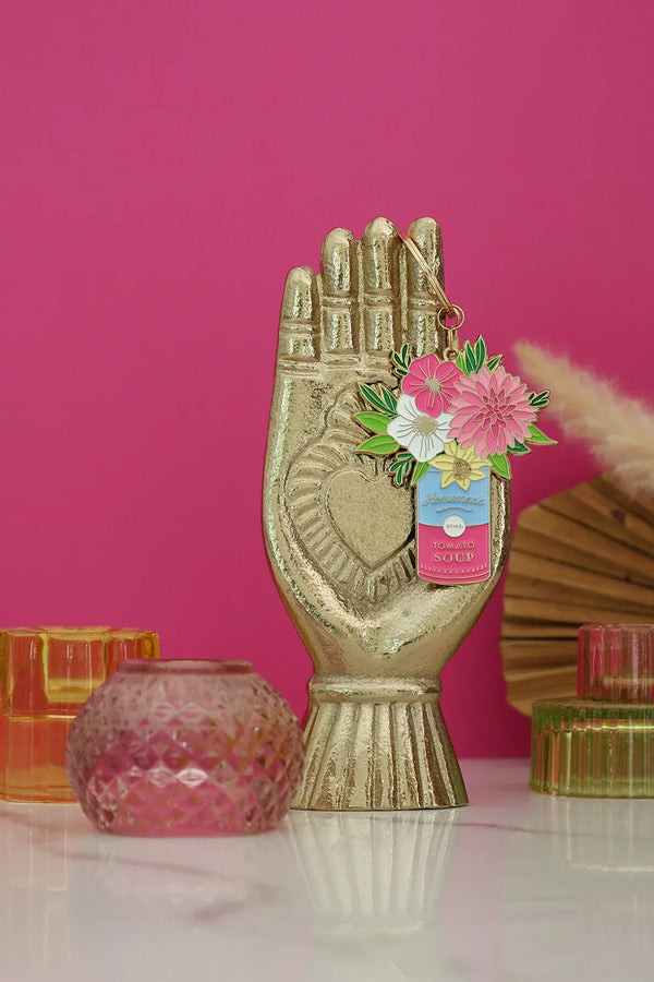 Flower Can keychain by All The Ways To Say displayed on golden hand statue with pink background