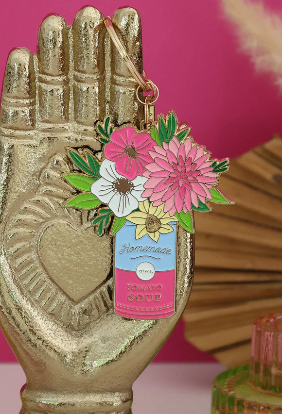 Close-up of Flower Can keychain showing detailed enamel flowers and gold-plated finish