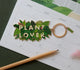 All The Ways To Say Plant Lover enamel keychain – lush green jungle leaves with gold details