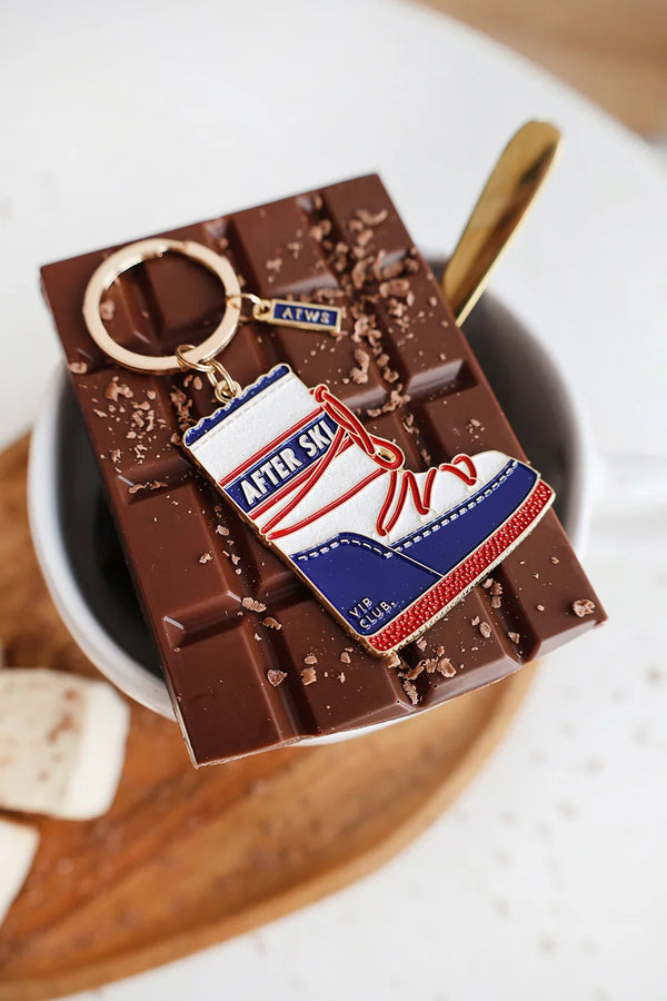 After Ski keychain by All The Ways To Say – enamel boot charm on melted chocolate background