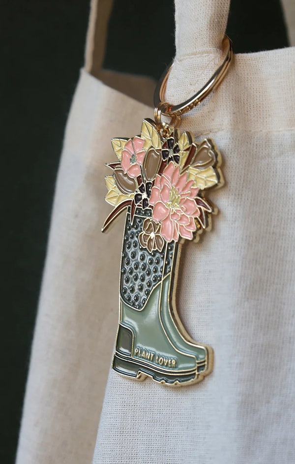 Pastel floral boot keychain by All The Ways To Say – enamel accessory hanging on beige fabric tote