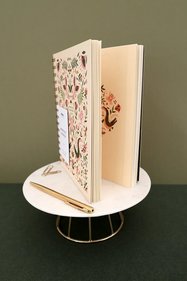 Interior Pink Croco monthly planner with floral and beetle illustration above calendar grid