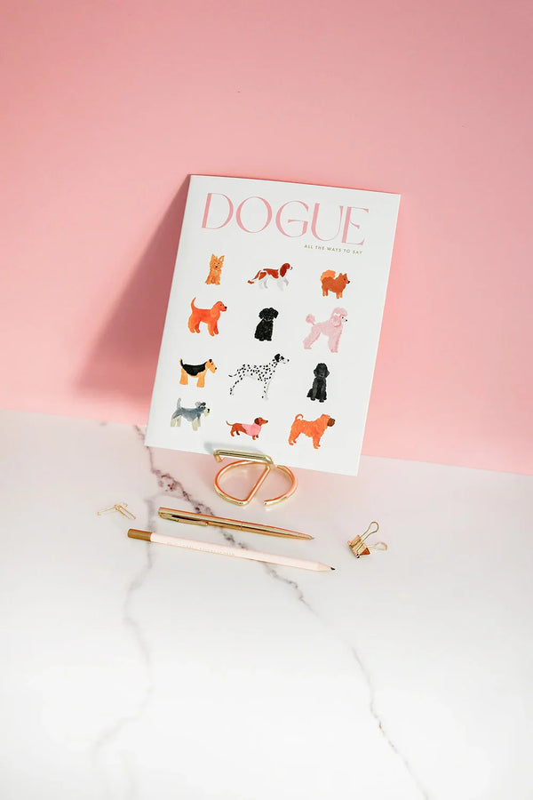 Cover of the Dogue monthly planner featuring colorful watercolor dog illustrations against a pink background with gold stationery.