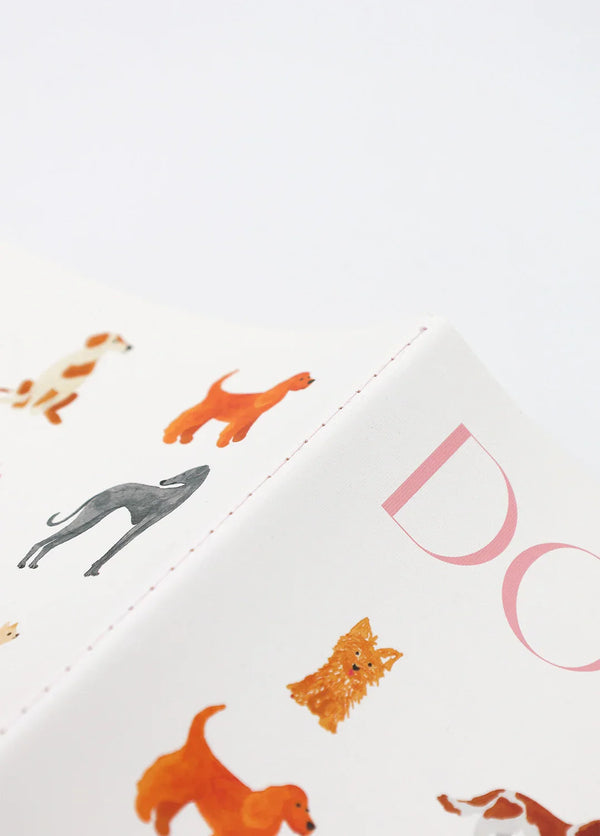 Close-up of Dogue monthly planner spine with detailed dog illustrations and pink typography
