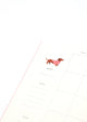 Inside page of Dogue monthly planner featuring a dachshund in a pink sweater with calendar layout