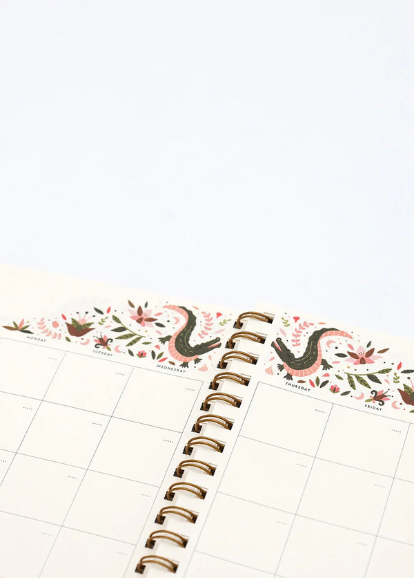 Interior Pink Croco monthly planner with floral and crocodile illustration above calendar grid