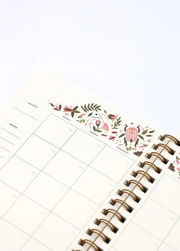 Interior Pink Croco monthly planner with floral and beetle illustration above calendar grid