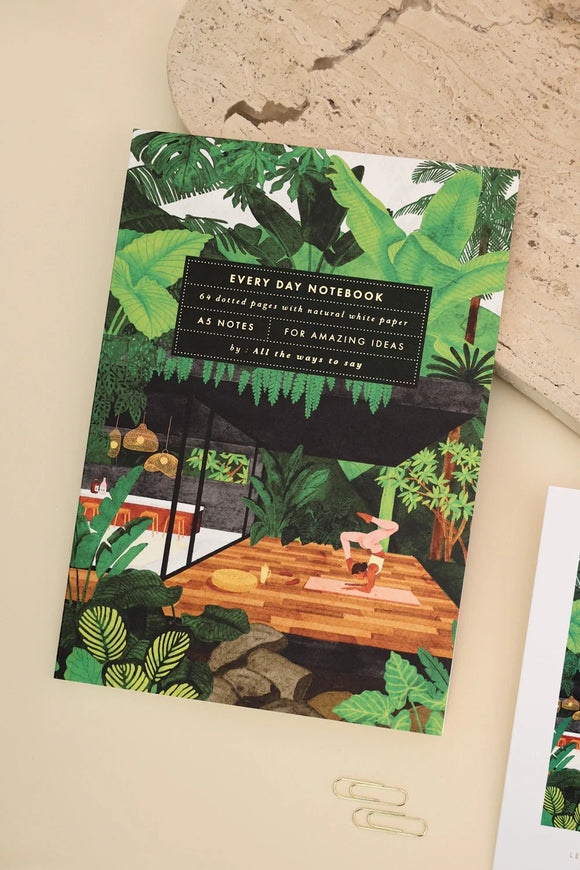 Illustrated notebook cover with yoga retreat design, featuring tropical plants and a woman practicing yoga on a wooden deck.
