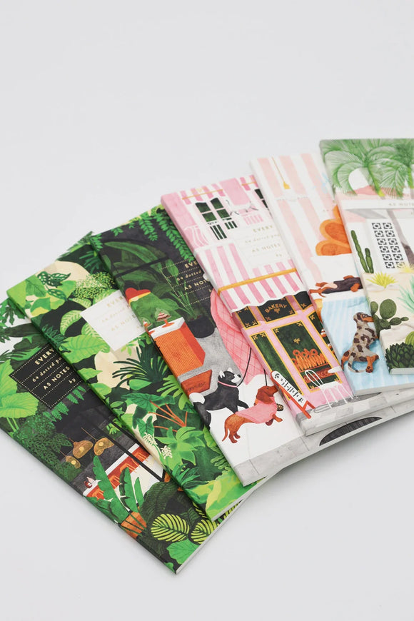 Collection of illustrated A5 notebooks with colorful covers, featuring botanical, architectural, and playful dog designs.