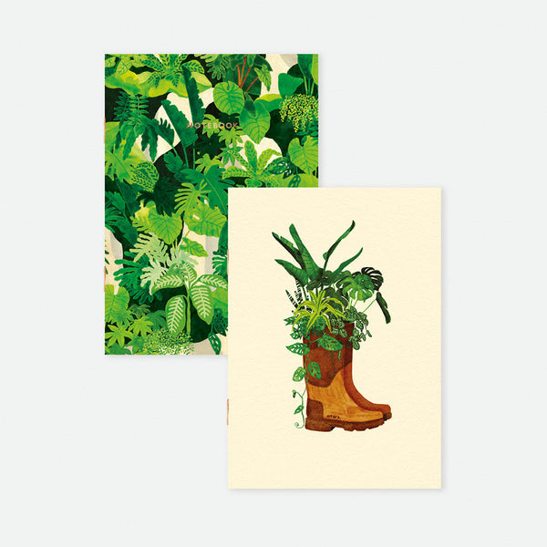 Set of two A6 pocket notebooks, one with dense green jungle leaves, the other with an illustrated gardening boot planter filled with plants, gold foil detail.