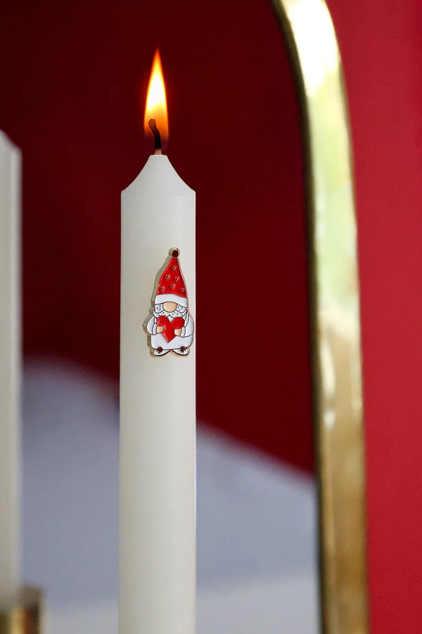 Grumpy Heart enamel pin by All The Ways To Say on lit candle with red wall and golden mirror reflection – cozy holiday scene