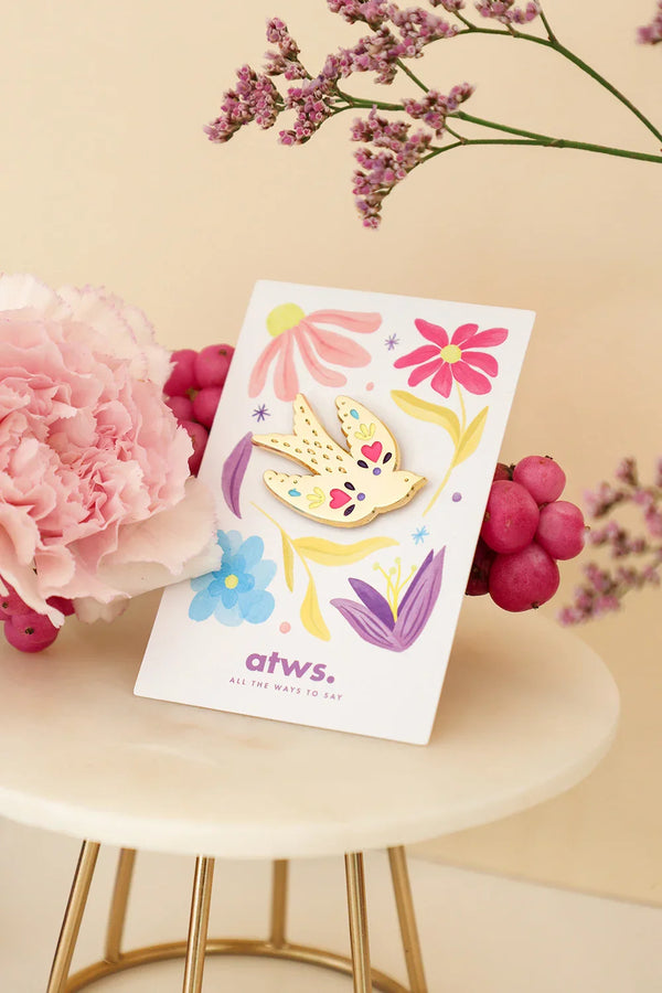 Lovebird enamel pin by All The Ways To Say on floral card with pink carnation and berries – beige background