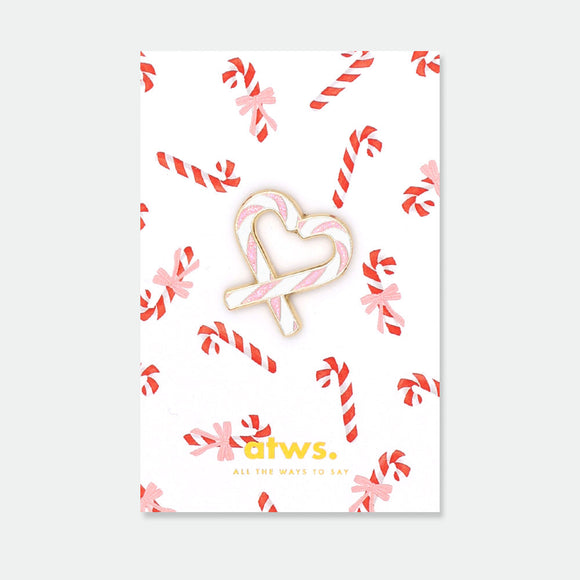 Sugar Heart enamel pin by All the Ways to Say featuring pink and white candy cane heart design with gold-plated details on festive candy background.