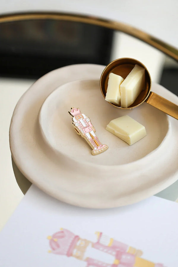 Pink Nutcracker enamel pin by All The Ways To Say on illustrated “Merry & Bright” card – pink background with gold pen