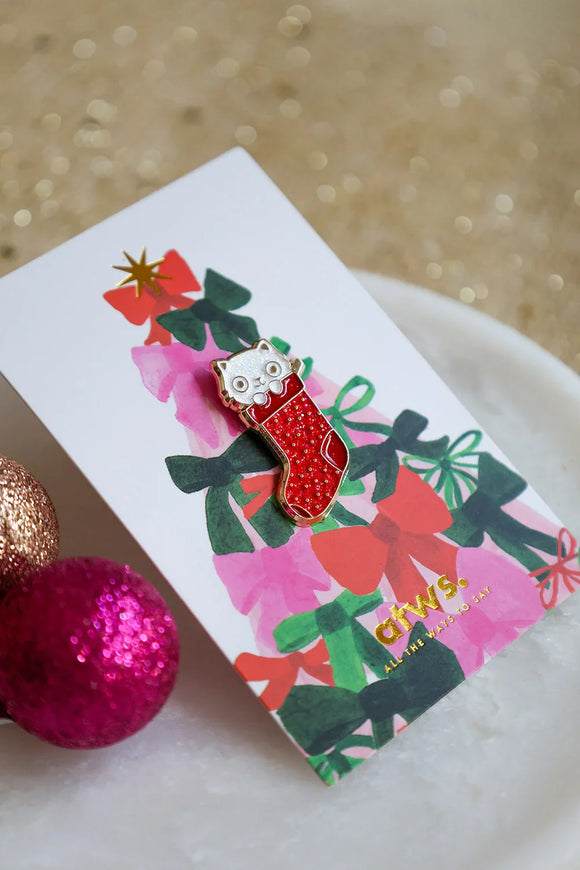 Close-up of Cat Sock enamel pin by All The Ways To Say – red stocking with cute cat face, holiday edition