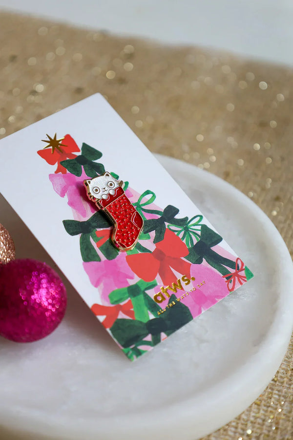 Cat Sock enamel pin on colorful Christmas card by All The Ways To Say – festive flatlay with pink and gold ornaments