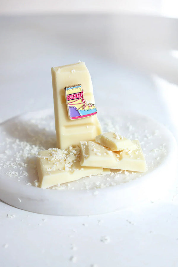 Cold AF enamel pin by All The Ways To Say – colorful moonboot design on white chocolate with coconut shavings