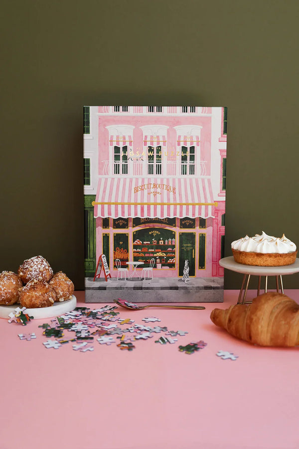 Close-up of Pink Bakery puzzle by All the Ways to Say, featuring a detailed Parisian storefront with pink and green tones and gold accents.