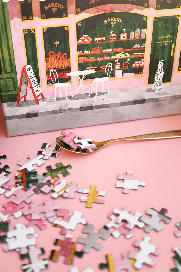 Cotton bag filled with colorful puzzle pieces from the Pink Bakery jigsaw puzzle by All the Ways to Say.