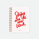 A spiral notebook with a pink striped cover and the text 'Stripes are the new black' written in a red, cursive font.