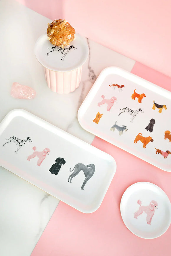 Set of white trays featuring colorful illustrated dogs on a pink and marble background — playful and elegant tableware design by All the Ways to Say.