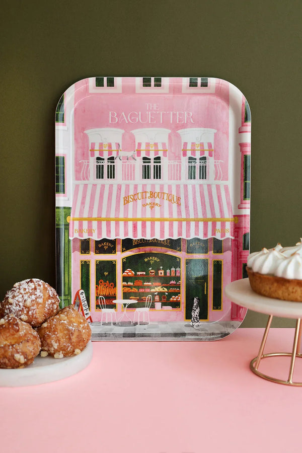 Rectangular tray “The Baguetter” with Parisian bakery illustration in pink tones, displayed beside pastries and a tart.
