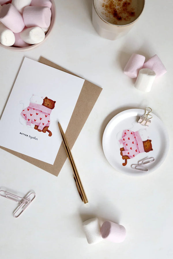 Cozy table scene with Together Cats tray coaster, coffee cup, marshmallows and stationery accessories