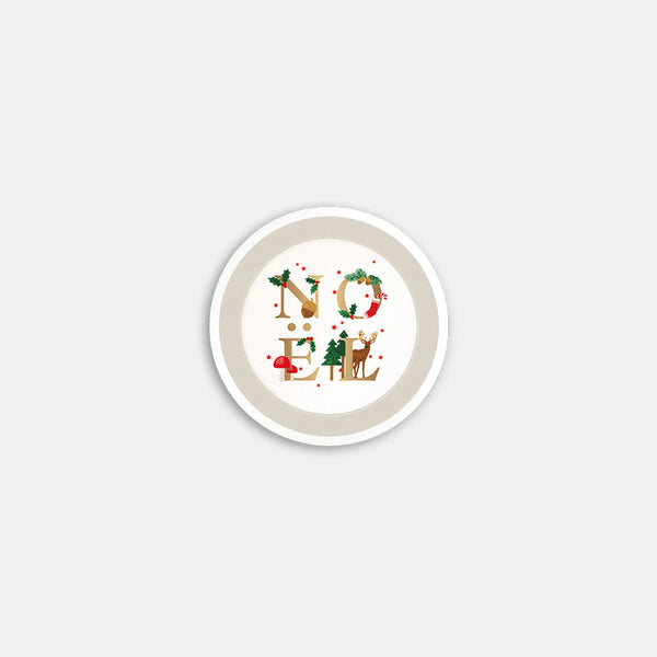 Round coaster with the word “Noël” illustrated using festive elements like holly, fir trees, mushrooms and a reindeer, Noël by All the Ways to Say