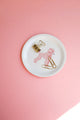 Small round tray featuring a pink poodle illustration on a pastel pink background, styled with gold stationery clips — All the Ways to Say.
