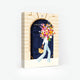 1000-piece jigsaw puzzle box by All The Ways To Say featuring a woman carrying a massive floral bouquet in front of a grand navy blue Parisian door.