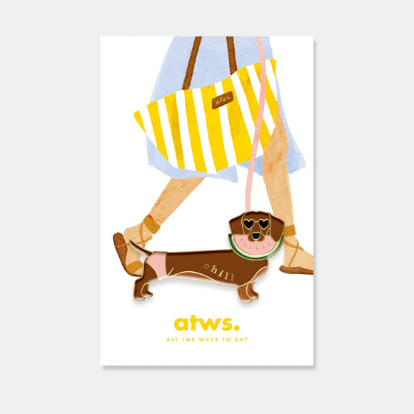 A cute dachshund enamel pin by All The Ways To Say wearing heart sunglasses and a watermelon floatie, with the word "chill" in gold.