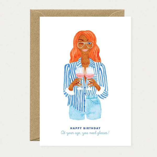 A witty greeting card by All The Ways To Say featuring a watercolor illustration of a woman holding two glasses of rose wine with the text "At your age, you need glasses!".