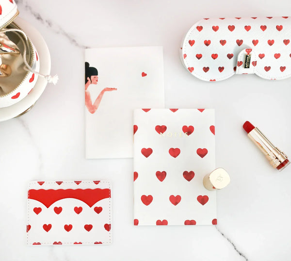 Red Hearts collection – card holder, glasses case and notebooks with red hearts design, styled with red lipstick.